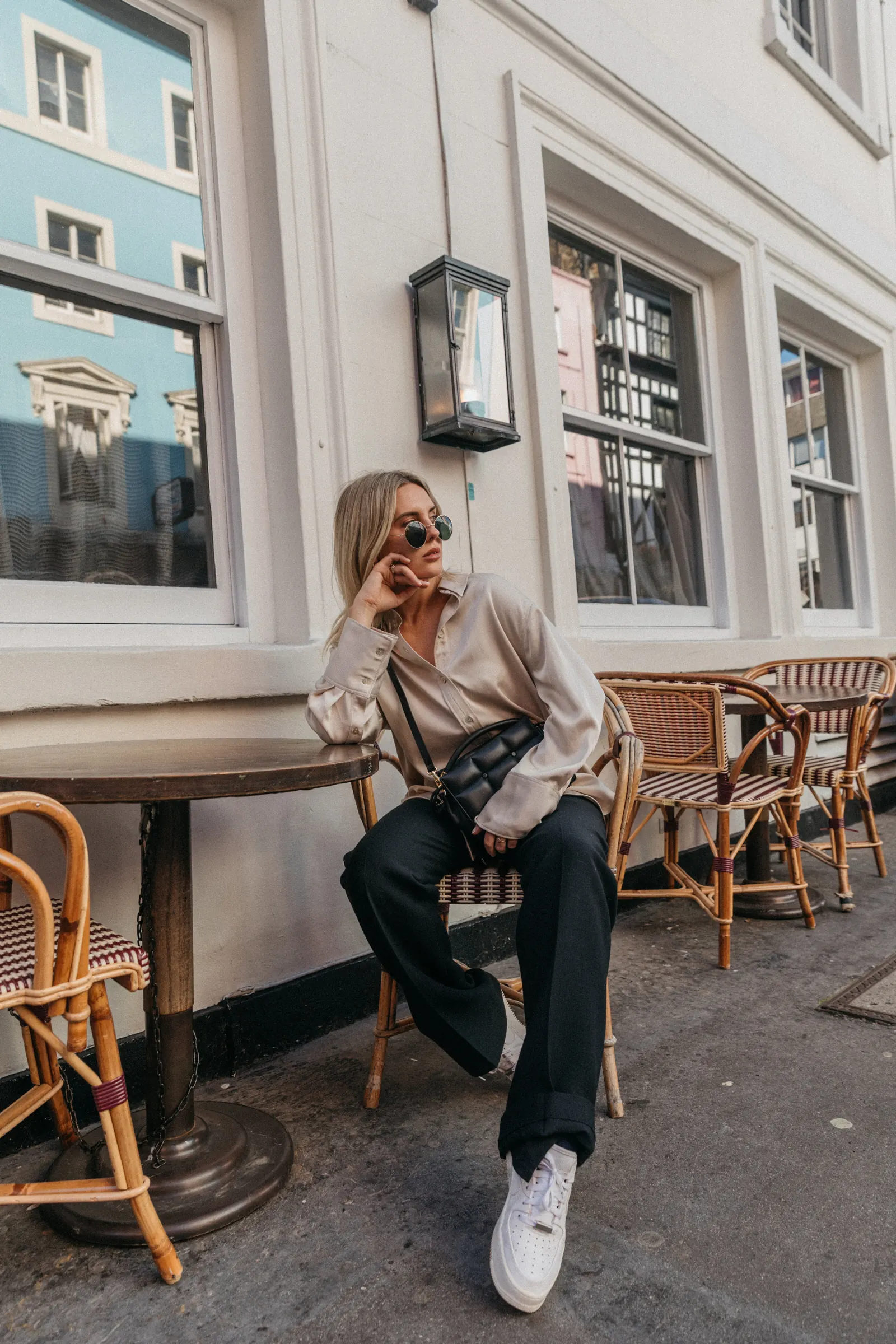 Emily at a cafe table outside a townhouse