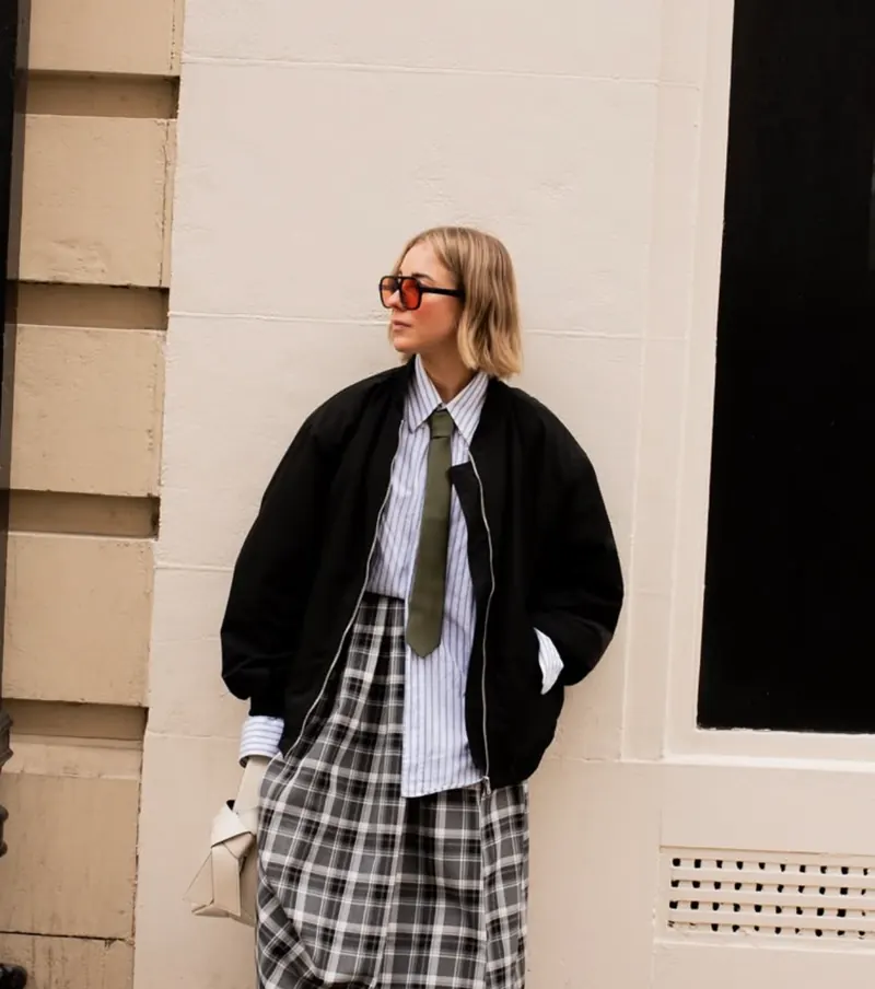 Sarah, petite fashion creator, in red sunglasses and a bomber jacket